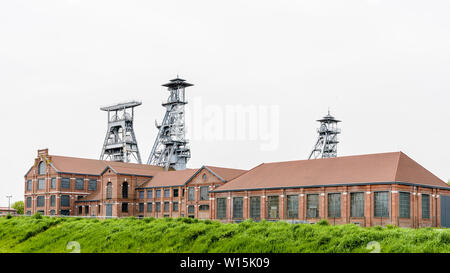 Die ehemalige Arenberg Mine in Wallers im Bergbau Becken des Nord-Pas-de-Calais, Frankreich, mit Welle Türme ragen über den Backsteinbauten. Stockfoto