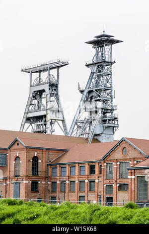 Die ehemalige Arenberg Mine in Wallers im Bergbau Becken des Nord-Pas-de-Calais, Frankreich, mit Welle Türme ragen über den Backsteinbauten. Stockfoto