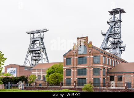 Die ehemalige Arenberg Mine in Wallers im Bergbau Becken des Nord-Pas-de-Calais, Frankreich, mit Welle Türme ragen über den Backsteinbauten. Stockfoto