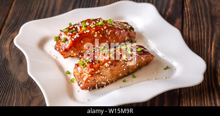 Zwei Stücke von teriyaki Lachs garniert mit Sesam und Frühlingszwiebel Stockfoto