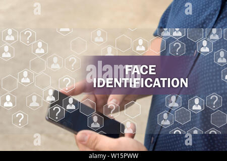 Biometrische Verifikation, eine Technologie zur Gesichtserkennung. Gesicht Identifizierungstaste auf der Touchscreen mit einem unscharfen Hintergrund der Geschäftsmann mit Th Stockfoto