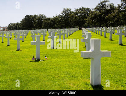 Amerikanische und französische Fahnen in der Mitte der Gräber von amerikanischen Soldaten, die während der Schlacht von Frankreich in der Normandie fiel Stockfoto