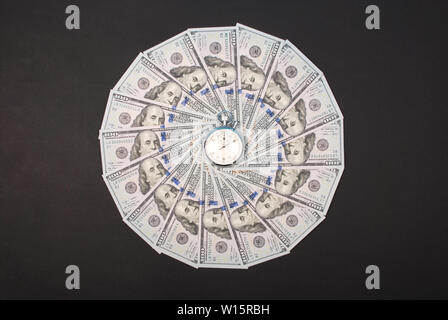 Stoppuhr auf dem Mandala Kaleidoskop von Geld. Abstrakte Geld Hintergrund raster Muster wiederholen Mandala Kreis. Stockfoto