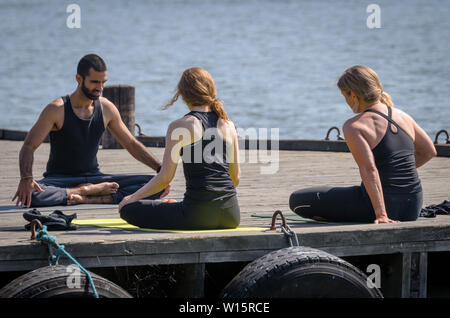 Yoga Übungen auf der steamboat Jetty Stockfoto