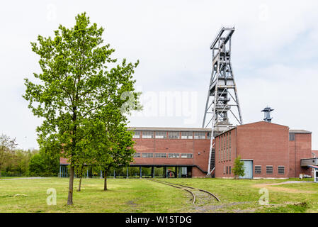 Eine große Welle aus Stahl Turm mit Backsteinbauten auf der ehemaligen Zeche Arenberg site in Wallers im Bergbau Becken des Nord-Pas-de-Calais, Frankreich. Stockfoto