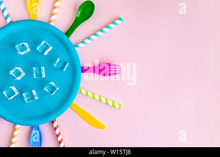 Flach der leeren Teller mit Eiswürfeln und bunten Kunststoff Besteck mit Trinkhalme gegen Pastell rosa Hintergrund minimal kreative Essen und Abakus Stockfoto