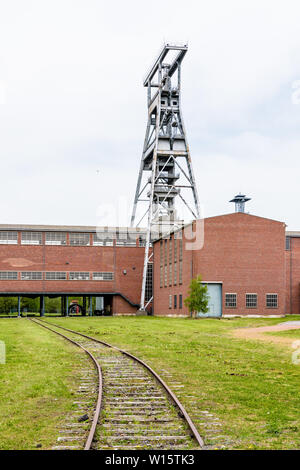 Eine große Welle aus Stahl Turm mit Backsteinbauten auf der ehemaligen Zeche Arenberg site in Wallers im Bergbau Becken des Nord-Pas-de-Calais, Frankreich. Stockfoto