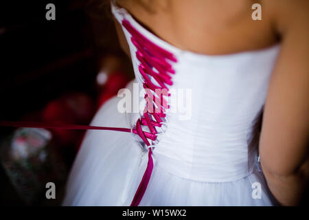 Braut von hinten. Schnürung das Hochzeitskleid. Stockfoto