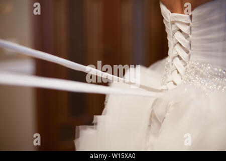 Braut von hinten. Schnürung das Hochzeitskleid. Stockfoto