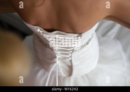 Braut von hinten. Schnürung das Hochzeitskleid. Stockfoto