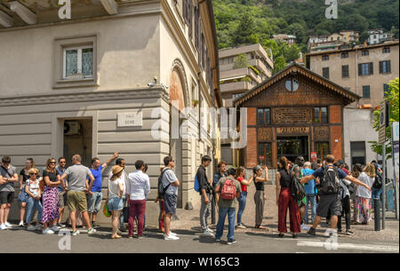 COMO, ITALIEN - Juni 2019: Lange Schlange von Menschen außerhalb der Talstation der Standseilbahn in Como am Comer See. Stockfoto