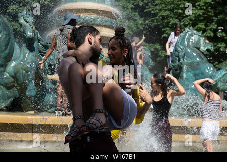 Menschen Abkühlen im Parc du Luxemburg Brunnen während der Gay Pride 2019, die auf eines der heißesten Tag des Jahres war. Stockfoto