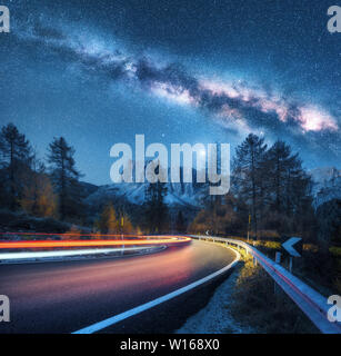 Milchstraße über Mountain Road. Verschwommen Autoscheinwerfer Stockfoto