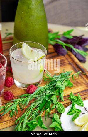 Sommer alkoholfreie Getränke, eine Reihe von limonaden. Limonaden in Krügen auf dem Tisch, die Zutaten, aus dem sie bestehen, sind um angeordnet. Stockfoto