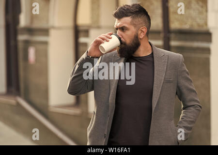 Entspannen und erholen Sie sich. Man bärtige hipster Pappbecher Kaffee trinken. Noch ein Schluck Kaffee. Kaffee trinken für Unterwegs. Geschäftsmann lumbersexual Erscheinungsbild genießen Sie Kaffee Pause aus Business Center. Stockfoto