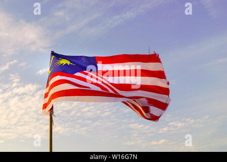 Malaysia Fahne winken beim morgendlichen Sonnenaufgang mit Himmel Hintergrund Stockfoto