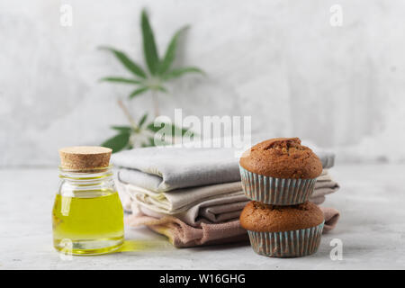 Verschiedene Produkte von Marihuana. Backen Muffins aus Cannabis, natürliche CDB Gewebe und Öl. Grauer Hintergrund Stockfoto