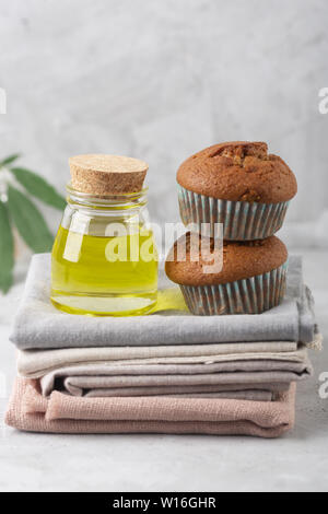 Verschiedene Produkte von Marihuana. Backen Muffins aus Cannabis, natürliche CDB Gewebe und Öl. Grauer Hintergrund, vertikale Ausrichtung Stockfoto