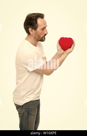 Valentines Tag feiern. Liebe und romantische Gefühle Konzept. Herz-Attribut von Valentine. Herz Geschenk präsentieren. Gruß aus ehrlichem Herzen. Man bärtige Hipster halten Herz. Romantischer Kerl verlieben. Stockfoto