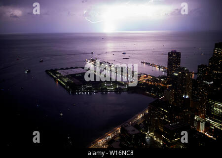 Blick von der 360 Chicago Observation Deck das John Hancock Building als Beleuchtung Streiks Lake Michigan in der Nacht über den Navy Pier Chicago IL USA Stockfoto