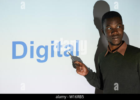 Ernsthafte selbstbewussten jungen Schwarzen seo Spezialist für Pullover gegen Projektionsfläche und Präsentation digitaler Projekt innovation Konferenz Stockfoto