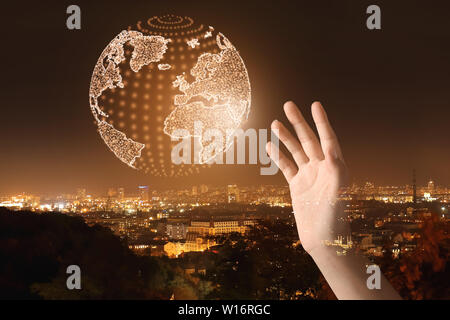 Double Exposure der weiblichen Hand mit digitalen Modell der Erde und der Stadt bei Nacht Stockfoto