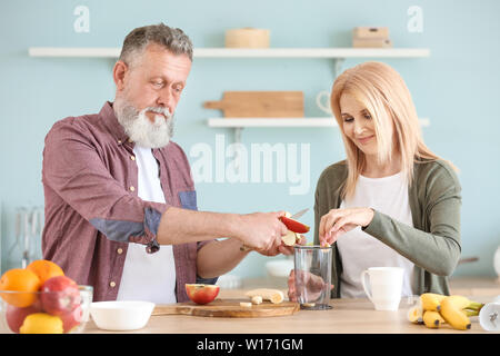 Gerne älteres Paar Vorbereitung Smoothie in der Küche Stockfoto