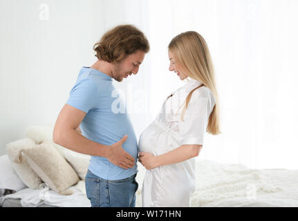 Glückliche junge schwangere Paare zu Hause Stockfoto