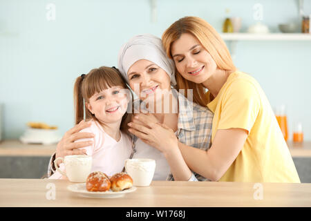 Reife Frau nach der Chemotherapie, die mit ihrer Familie in der Küche zu Hause. Stockfoto