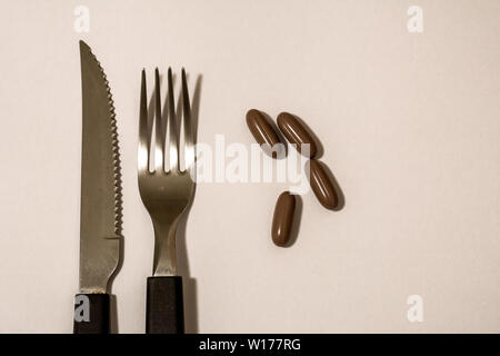 Kapseln, Pillen, Messer und Gabel, als wäre es das Essen der Zukunft. Stockfoto