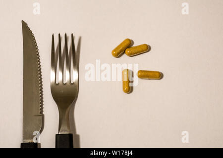 Kapseln, Pillen, Messer und Gabel, als wäre es das Essen der Zukunft. Stockfoto