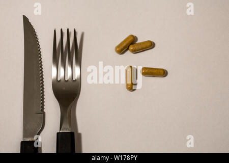 Kapseln, Pillen, Messer und Gabel, als wäre es das Essen der Zukunft. Stockfoto