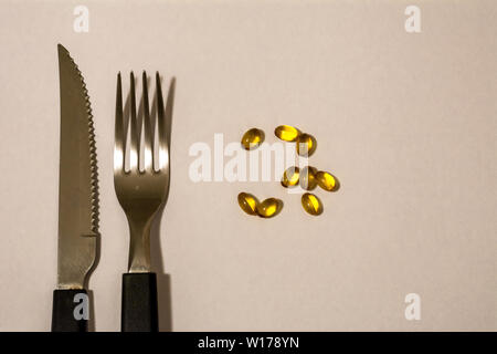 Kapseln, Pillen, Messer und Gabel, als wäre es das Essen der Zukunft. Stockfoto