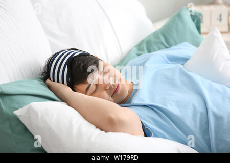 Hübscher junger Mann schlafen im Bett Stockfoto