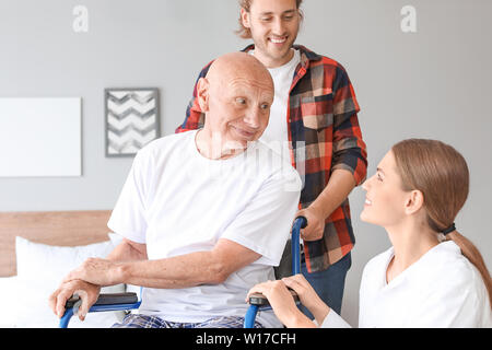 Junger Mann seinen Vater im Pflegeheim besuchen Stockfoto