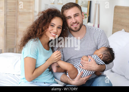 Portrait von Happy interracial Familie im Schlafzimmer Stockfoto