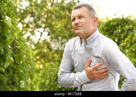 Reifer mann Leiden von Herzinfarkt im Freien Stockfoto