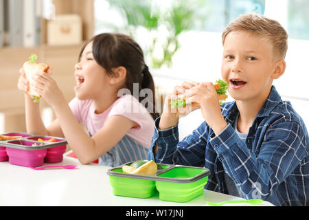 Schüler mit Mittagessen im Klassenzimmer Stockfoto