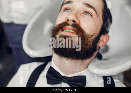 Stilvolle Mann sitzt in einem Barbershop Stockfoto