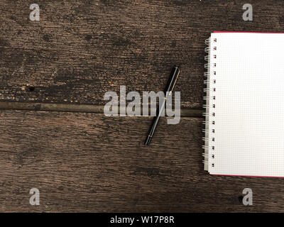 Seite "Notizbuch" und schwarzen Stift auf alten Holztisch Hintergrund mit kopieren. Leere Notepad öffnen Blatt auf einem dunklen Holz- Oberfläche. Ansicht von oben Hinweis öffnen Boo Stockfoto