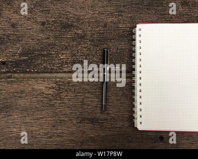 Seite "Notizbuch" und schwarzen Stift auf alten Holztisch Hintergrund mit kopieren. Leere Notepad öffnen Blatt auf einem dunklen Holz- Oberfläche. Ansicht von oben Hinweis öffnen Boo Stockfoto