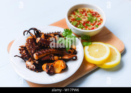 Oktopus Salat mit Zitrone Kräuter und Gewürze auf weiße Platte/Tentakel Tintenfisch gegrillt Vorspeise essen heiß und würzig Chili Sauce gekocht serviert Meeresfrüchte Stockfoto