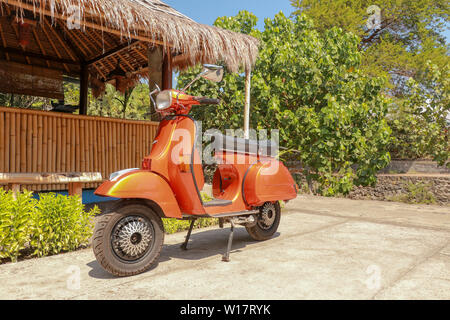 Orange Classic Vespa. Eine alte orange und schwarz Vespa Super motorscooter ist auf einem Bürgersteig geparkt. Stockfoto