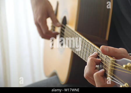 Mittelteil der junge Mann spielt akustische Gitarre Stockfoto