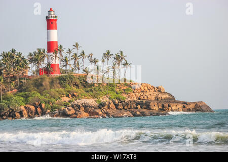 Einen felsigen Strand in Goa, Kerala mit einem Leuchtturm im Hintergrund. Stockfoto