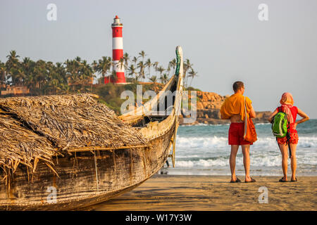 Kerala, Indien: Dated-June 14, 2019: Ein Strand in Kerala Goa mit einem Leuchtturm im Hintergrund und einem traditionellen Fischerboot im Vordergrund. Foreig Stockfoto