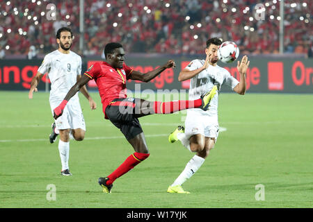 Kairo, Ägypten. 30. Juni, 2019. Timothy Dennis Awany (C) der Uganda Mias mit Mahmoud Ahmed Ibrahim Hassan von Ägypten während der 2019 Afrika Cup der Nationen, eine Übereinstimmung in Kairo, Ägypten, 30. Juni 2019. Credit: Wang Teng/Xinhua/Alamy leben Nachrichten Stockfoto