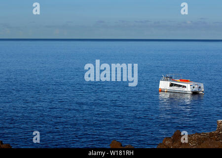 Boot im Atlantischen Ozean vor der Küste von Madeira am frühen Morgen festgemacht, bevor Urlauber ankommen. Stockfoto