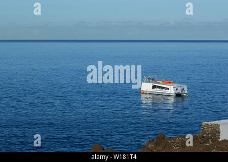 Boot im Atlantischen Ozean vor der Küste von Madeira am frühen Morgen festgemacht, bevor Urlauber ankommen. Stockfoto