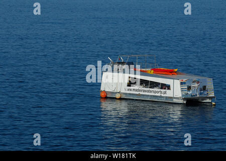 Boot im Atlantischen Ozean vor der Küste von Madeira am frühen Morgen festgemacht, bevor Urlauber ankommen. Stockfoto